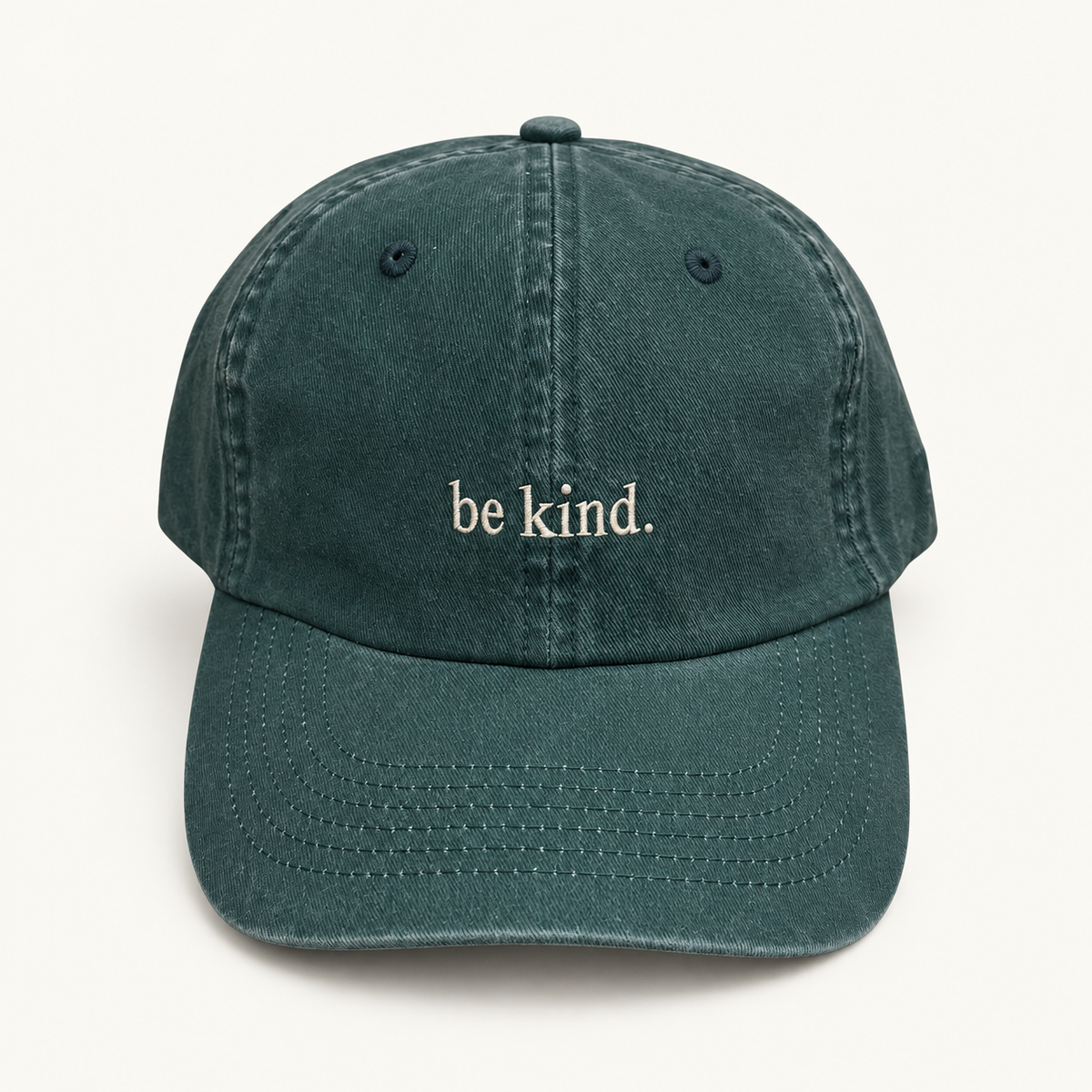 Pine green Daily Pause hat with cream be kind. embroidery on an ivory background